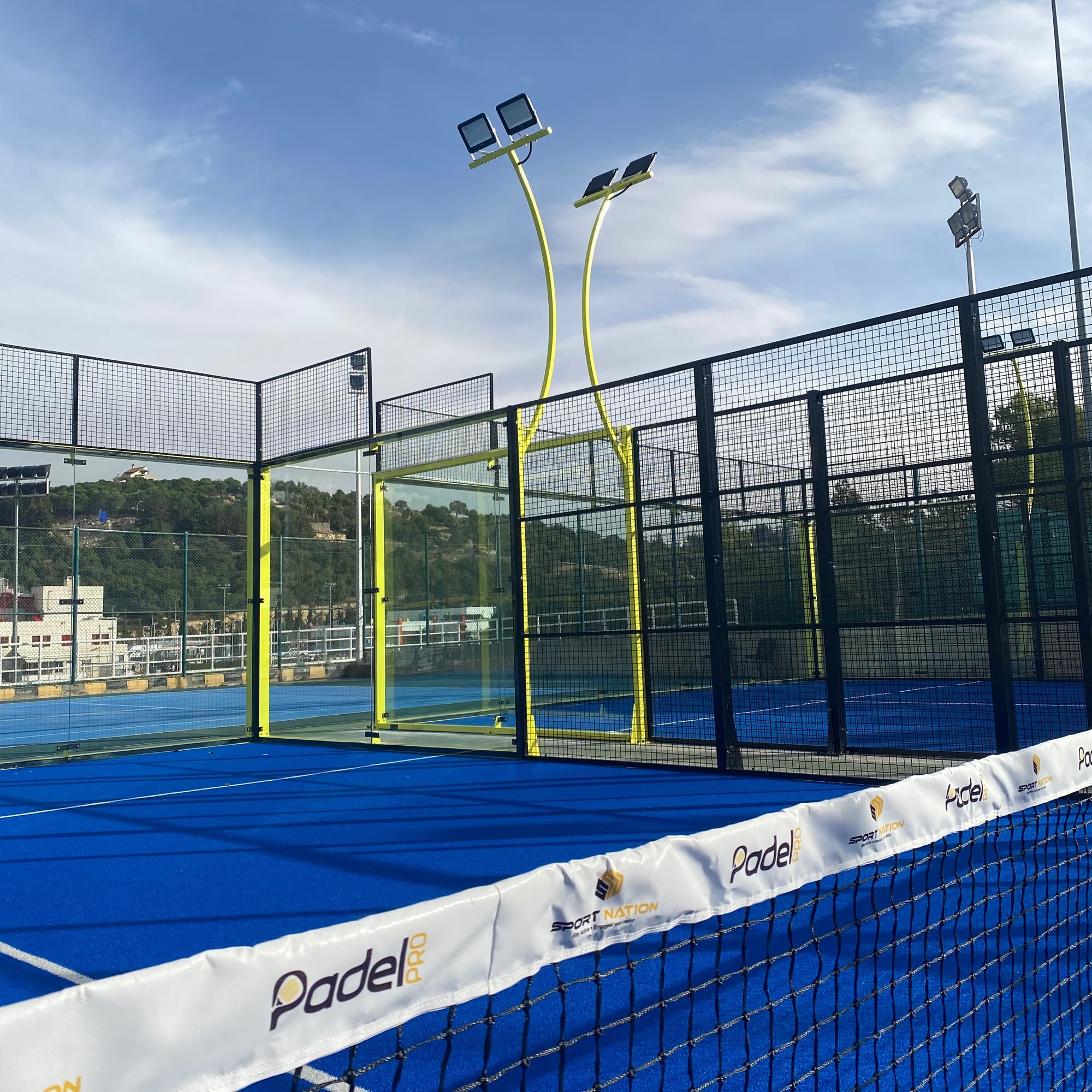 Padel Pro's blue court with yellow floodlight posts at the Amman Baccalaureate School
